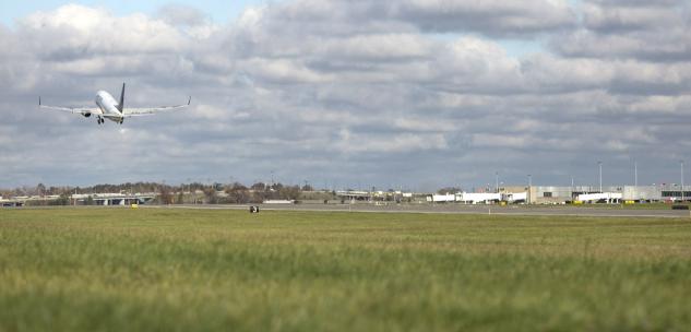 Plane taking off over runway and field at CLE